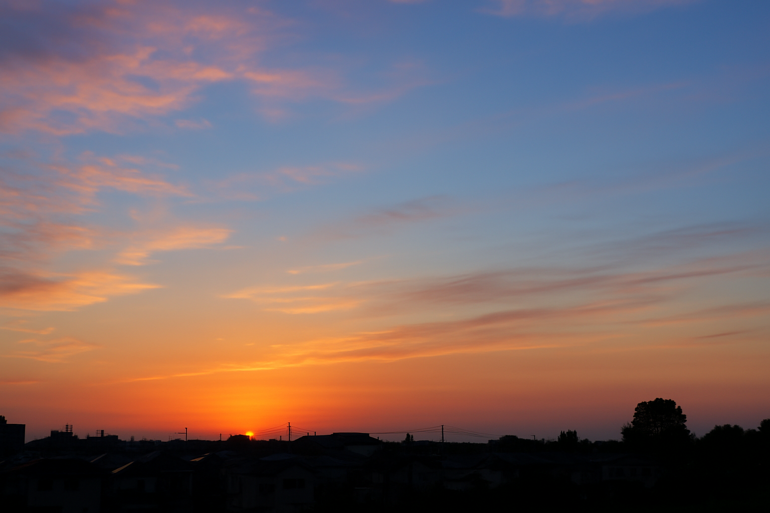 夕暮れに染まる空と街並みの影。夏の名残を感じながら秋の訪れを告げる風景。 A sky painted by dusk with silhouettes of the town, evoking both the lingering summer and the coming autumn.